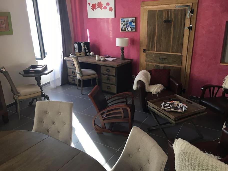 - un salon avec une table, des chaises et un bureau dans l'établissement Gites de Climats de 3 à 6 personnes, à Beaune