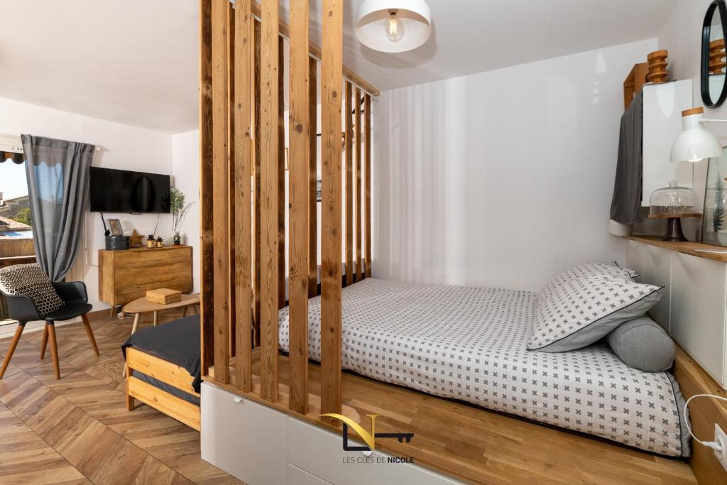 1 dormitorio con 1 cama con marco de madera en Magnifique petit cocon bord de mer- Lesclesdenicole en Le Pradet
