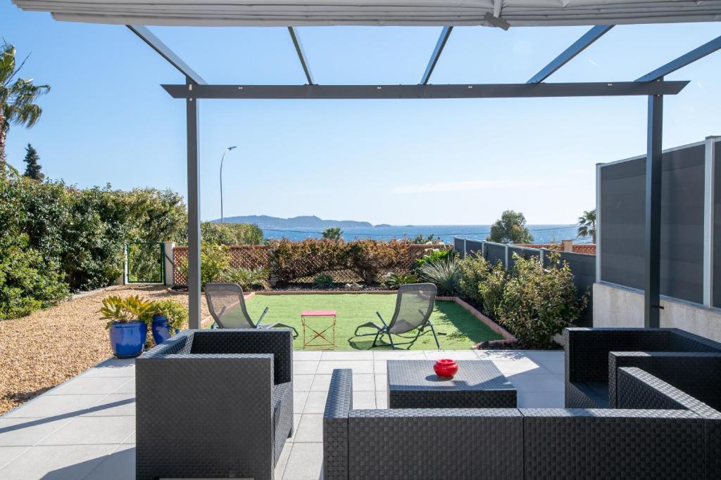 um pátio com vista para o mar a partir de uma casa em Face à la mer superbe villa terrasse barbecue LE PRADET em Carqueiranne