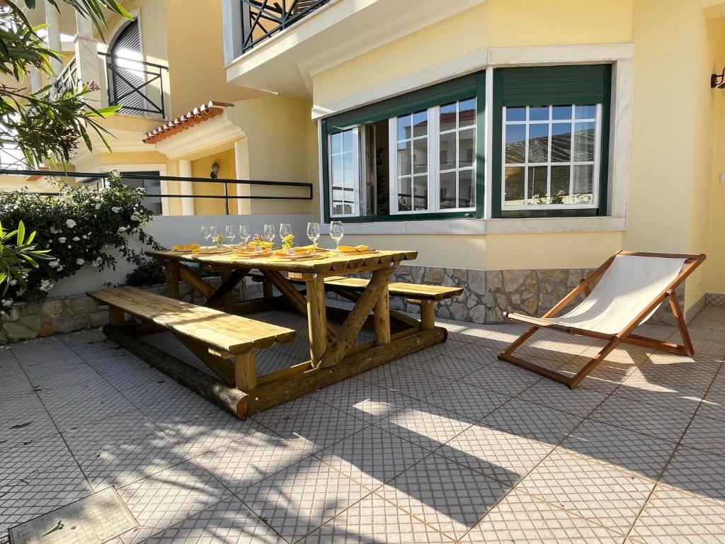 une table en bois et une chaise sur la terrasse dans l'établissement Yellow House Ericeira, à Ericeira
