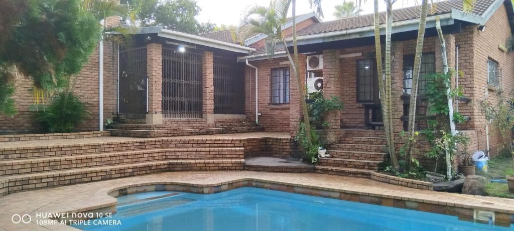 a house with a swimming pool in front of it at Sthembile's guest house in Richards Bay