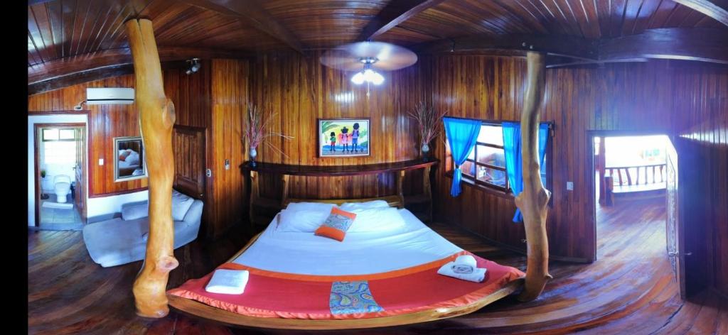 um quarto com uma cama num quarto com paredes de madeira em Hotel La Isla Inn em Puerto Viejo