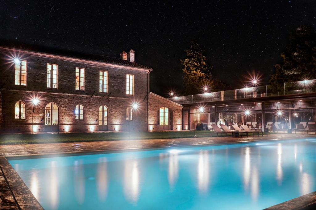 a swimming pool in front of a building at night at Terra di Gradara in Gradara