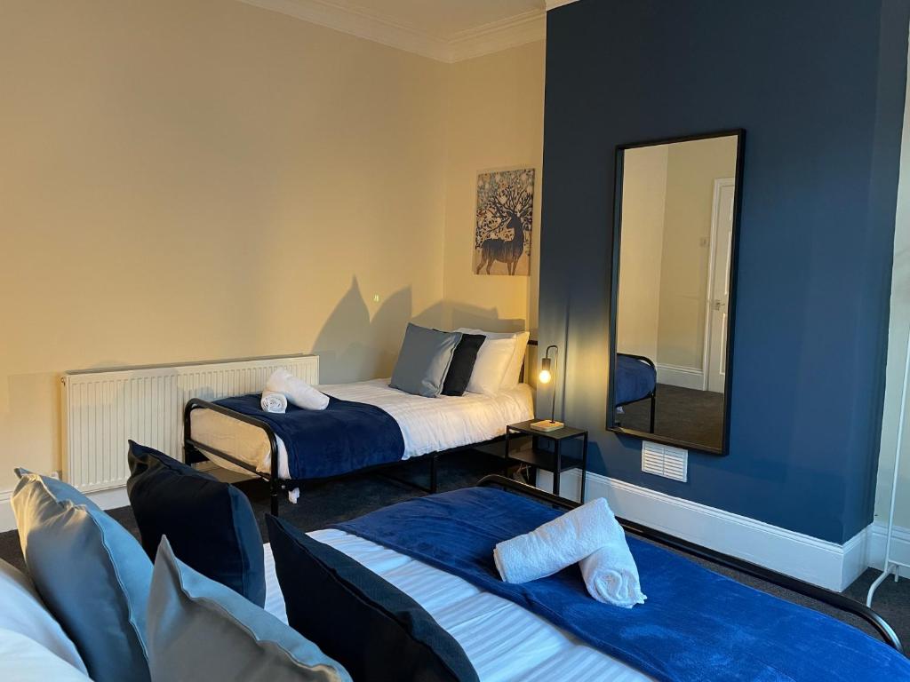 a hotel room with two beds and a mirror at Howe - Newly refurbished 2 bedroom flat Free Parking in Gateshead