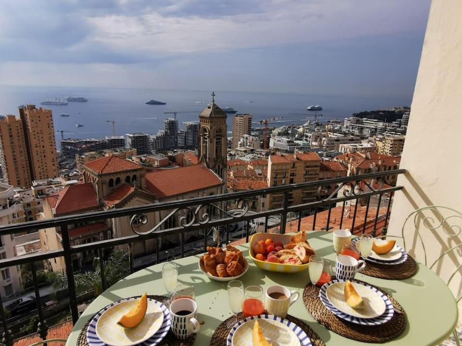 a table with plates of food on top of a balcony at Vista Monaco, 5mn walk to Monaco, Amazing view in Beausoleil