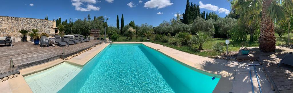 a swimming pool in a resort with a blue at VILLA NIMES BARTHEROES 3 Chambres in Marguerittes