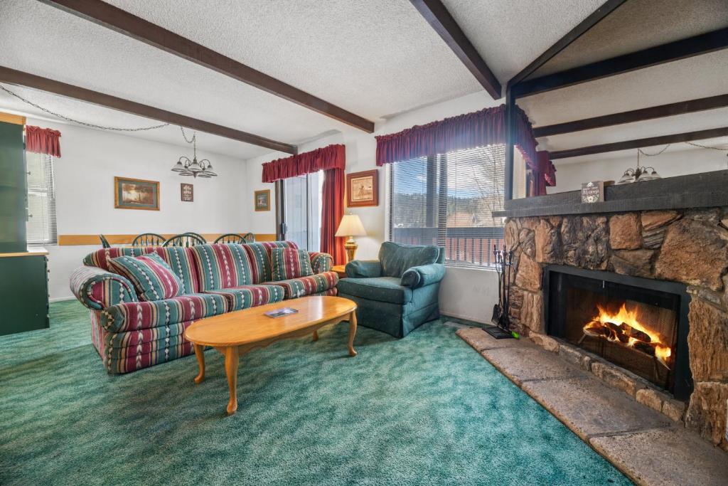 sala de estar con sofá y chimenea en Boulder Bay Chalet Condo - Mountain charm condo with lake view and WIFI!, en Big Bear Lake