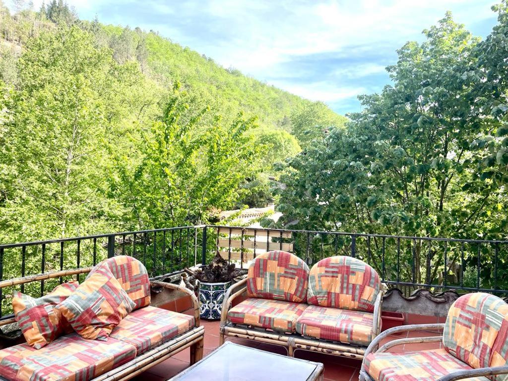 2 sillas y una mesa en un balcón con árboles en Escapada rural para descansar - Cicloturismo - Provincia Girona en Osor