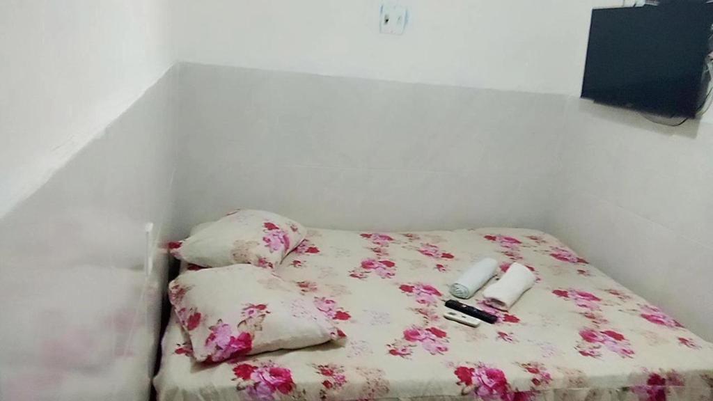 a bed with flowers on it in a room at Pousada Terra do Sol in Fortaleza