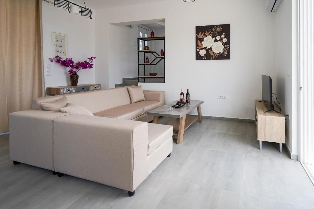 sala de estar con sofá y mesa en Sunshine House Kos - Easy living by the sea, en Kefalos