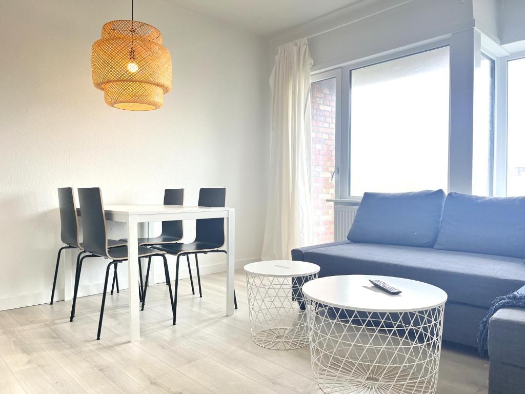 sala de estar con sofá azul, mesa y sillas en Newly Renovated Apartment With 1 Bedroom In Kolding en Kolding