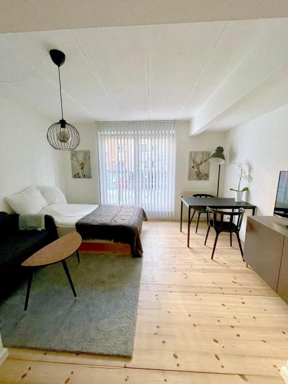 ein Wohnzimmer mit einem Bett und einem Tisch in der Unterkunft Great Modern Studio in Aalborg