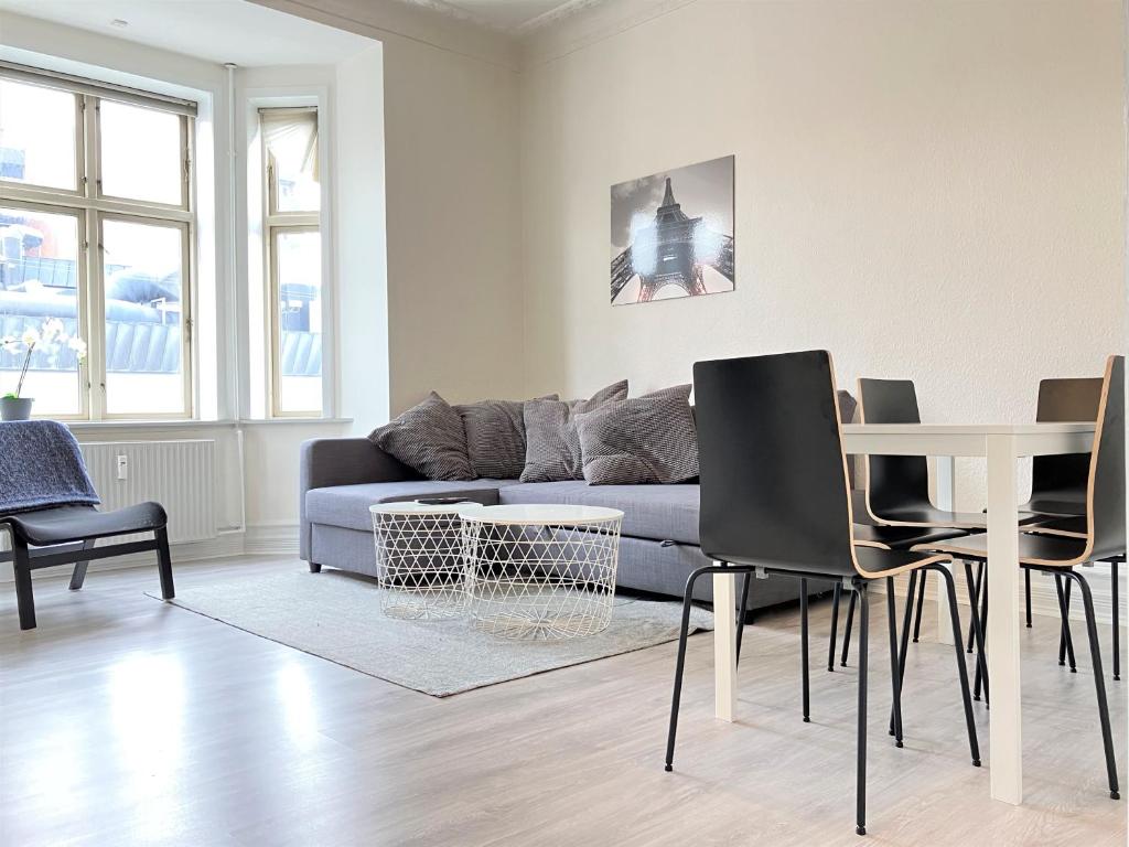 Una sala de estar con un sofá, una mesa y sillas. en Two Bedroom Apartment In Esbjerg, Tordenskjoldsgade 24, en Esbjerg