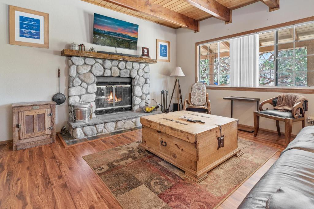 a living room with a stone fireplace and a couch at Hikers Haven -Only steps to the National Forest and trails! in Big Bear City