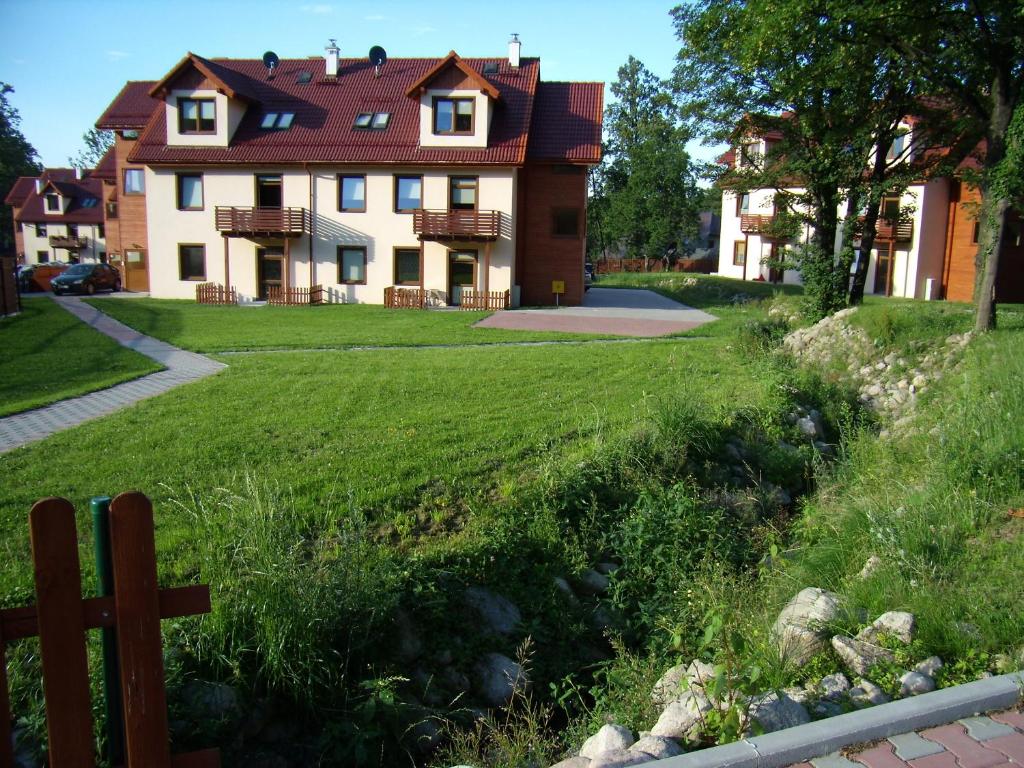 a house with a cross in front of a yard at Apartament nad Łomniczką in Karpacz