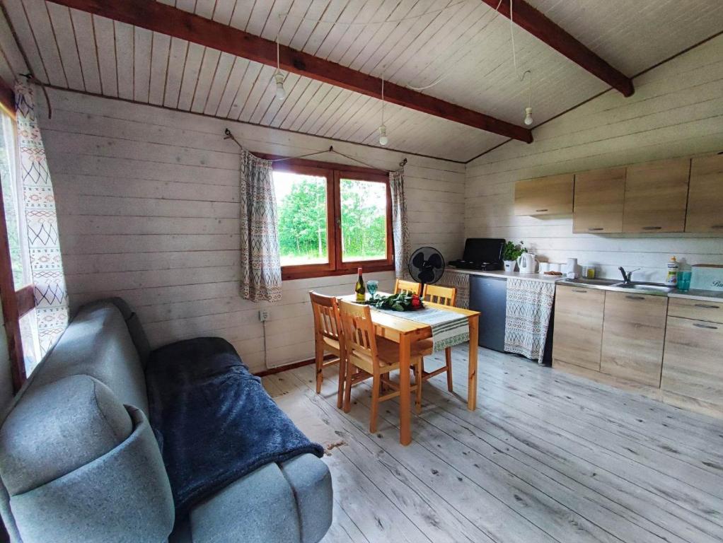 a living room with a table and a couch and a kitchen at Bojkolandia in Ustrzyki Dolne