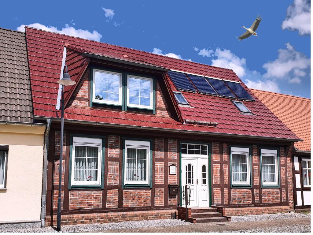 une maison dotée d'un toit rouge avec des panneaux solaires dans l'établissement Ferienwohnung 1, unten, à Bad Wilsnack