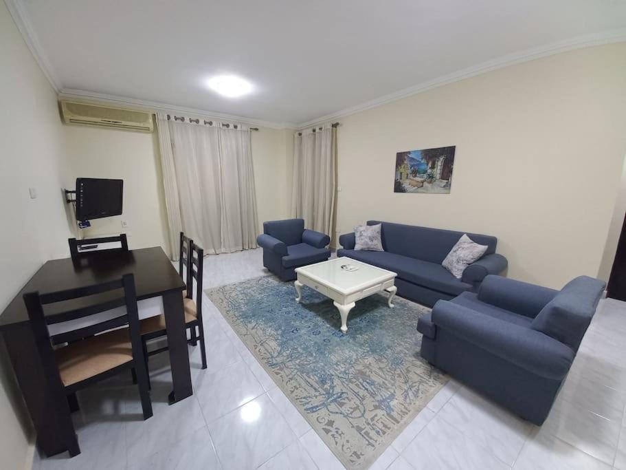ein Wohnzimmer mit einem blauen Sofa und einem Tisch in der Unterkunft Relaxing Apartment with garden view in New Cairo in Kairo