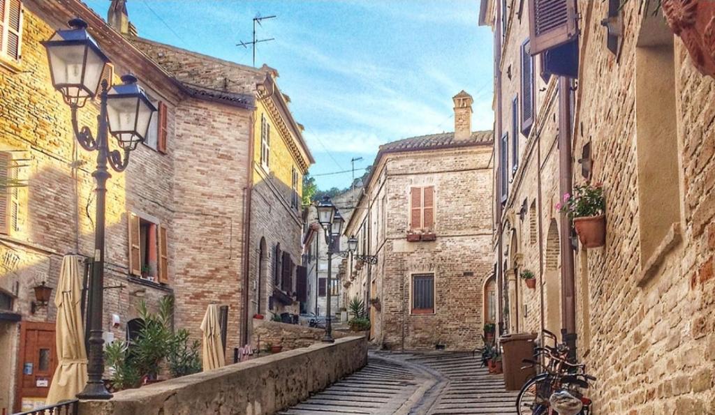 an alley with stone buildings and a bike on a street at A CASA DI NONNA LUISA in Porto San Giorgio