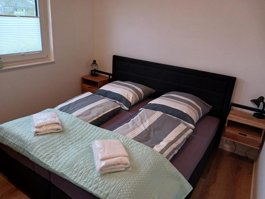 two beds in a room with two towels on them at Ferienhaus Seehuis, Sauna, angeln, familienfreundlich in Twist