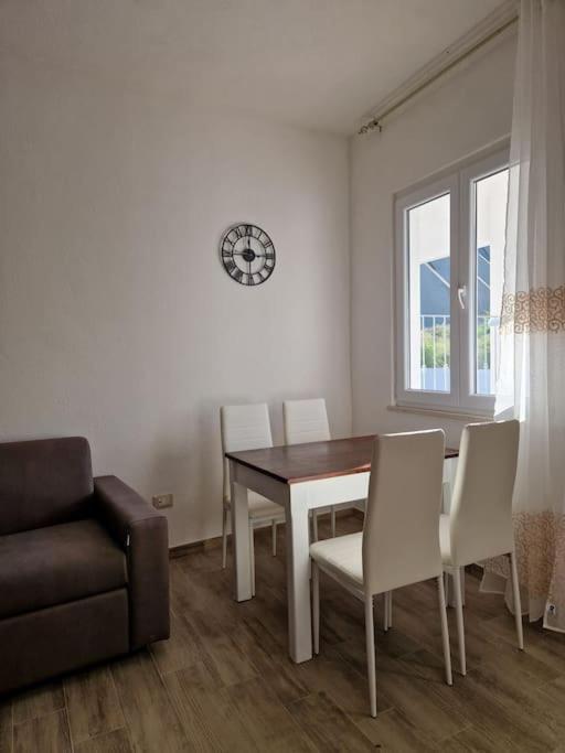 a dining room with a table and chairs and a clock at Casa Rosa Forio d'Ischia in Forio d'Ischia
