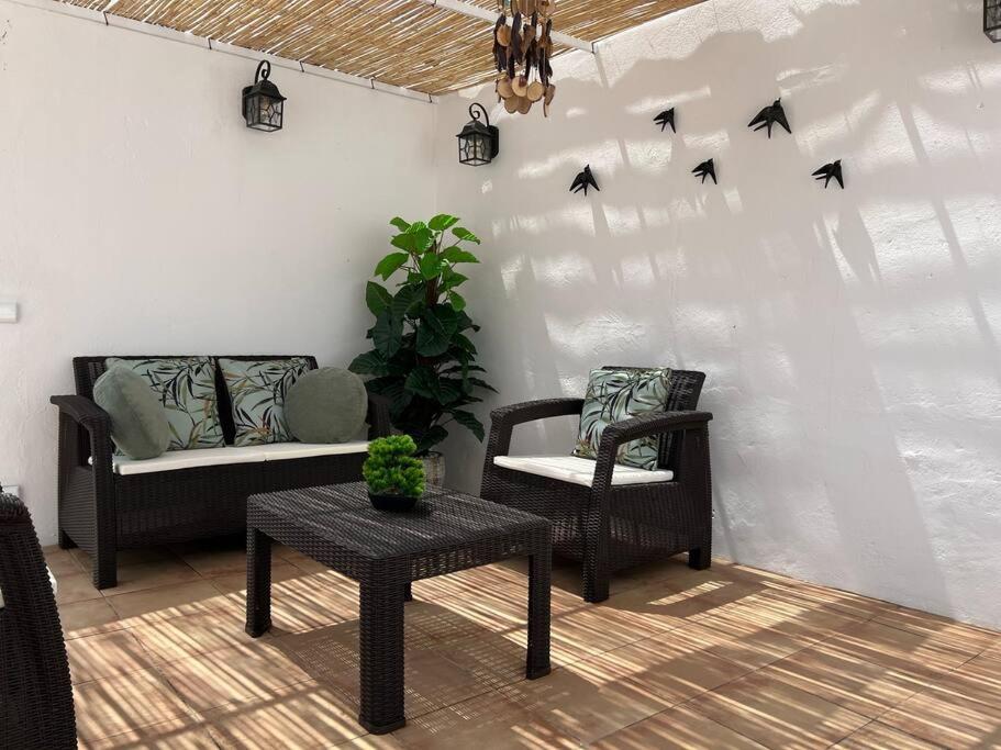 a living room with chairs and birds on the wall at Casa Santiago & Mafalda Lux Home in Olhão