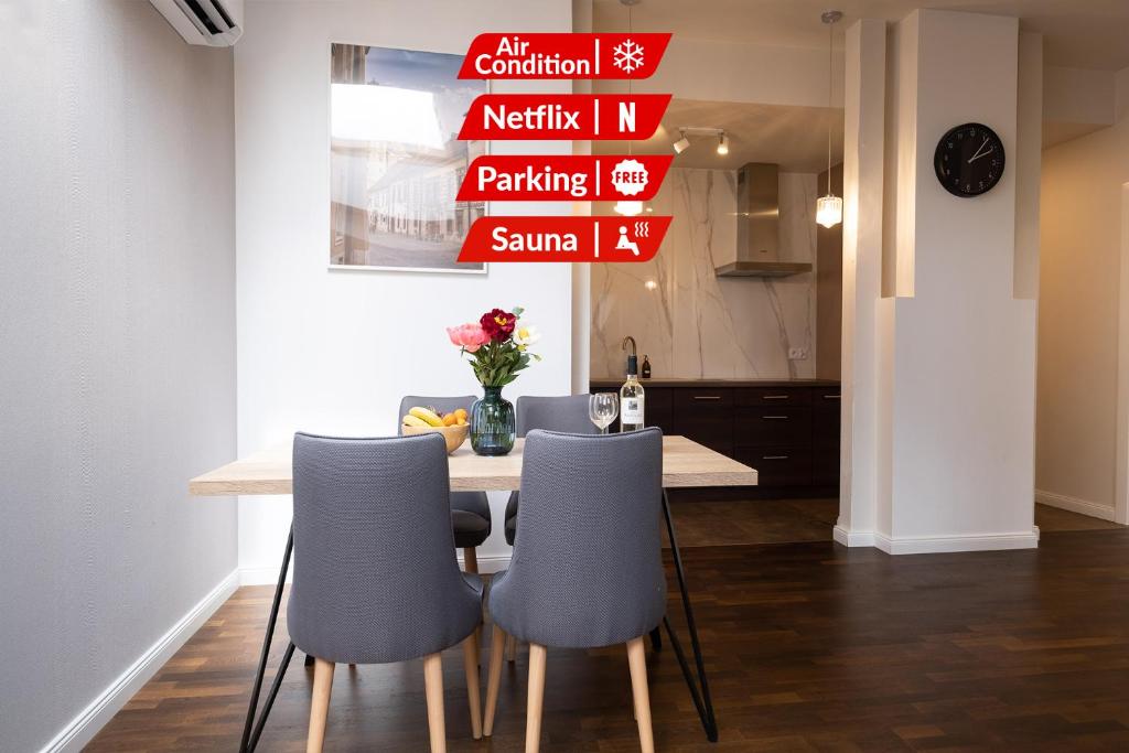 a dining room with a table and chairs and signs at Old Town Vistula Premium Apartments in Krakow