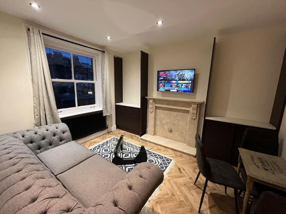 a living room with a couch and a flat screen tv at Beautiful Central London Apartment in London