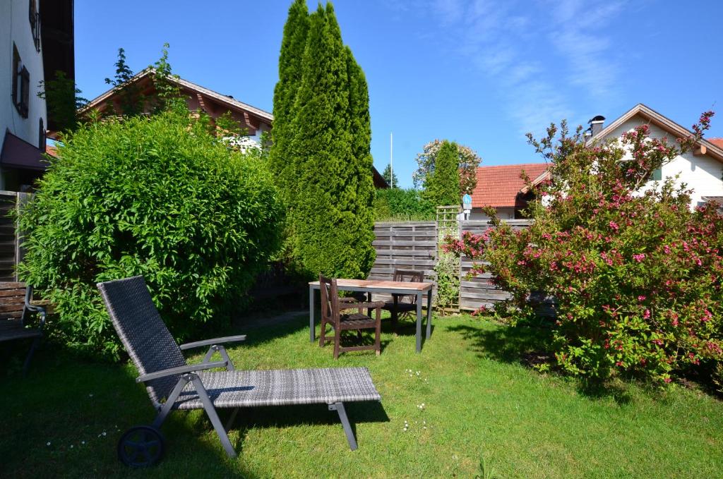 un jardin avec une chaise, une table et un banc dans l'établissement "Beim Brugger", à Lechbruck am See
