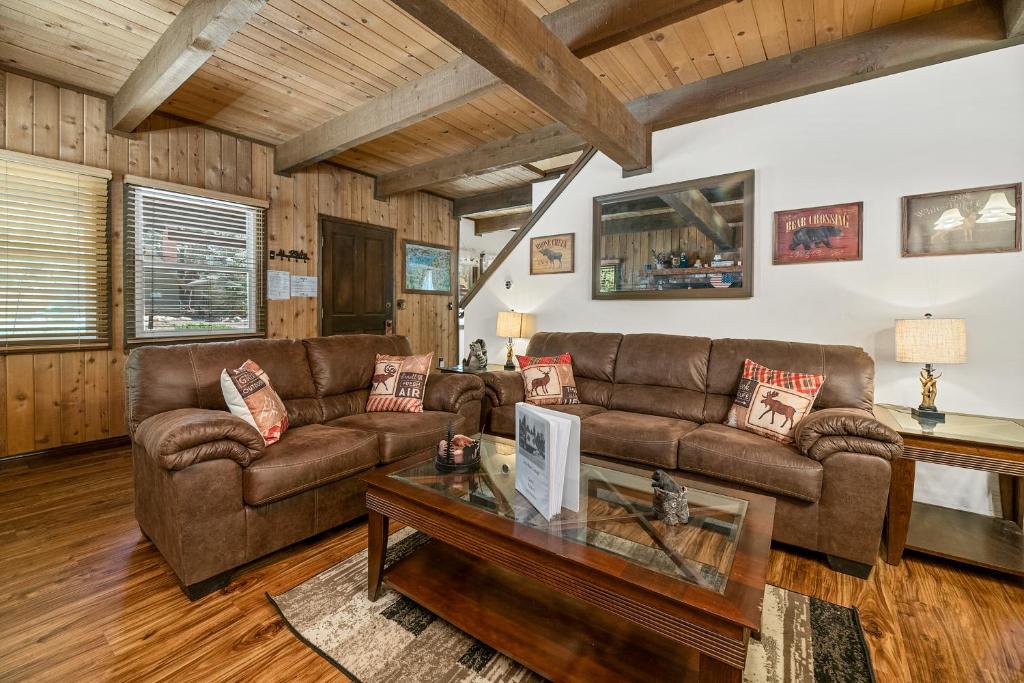 a living room with two brown couches and a table at Little Bear Cottage - Cozy, quaint cabin with a great fireplace and so many fun board games! in Big Bear Lake