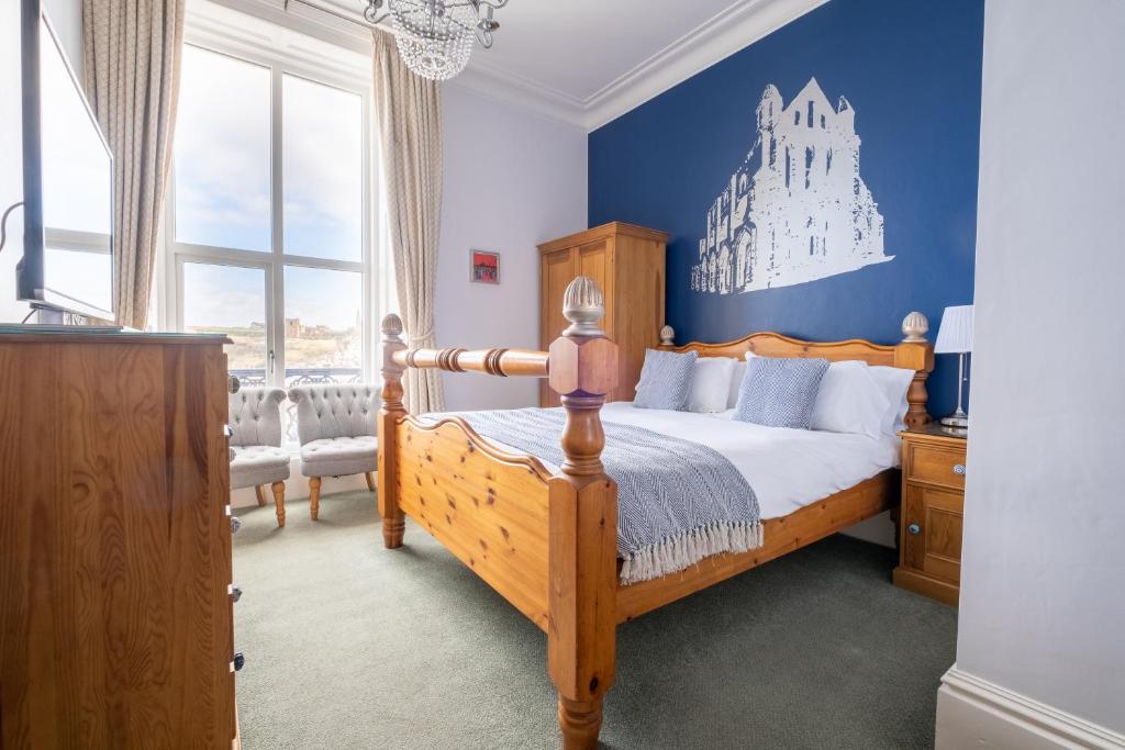 sypialnia z drewnianym łóżkiem i niebieską ścianą w obiekcie Number 7 Guest House w mieście Whitby