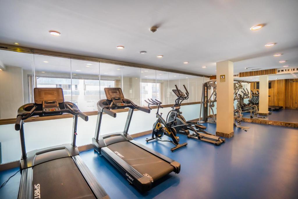 a gym with several treadmills and elliptical machines at Hotel Spa Cádiz Plaza in Cádiz