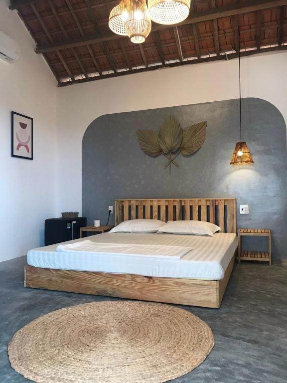 a bedroom with a large bed with a wooden headboard at Blue Sea Homestay 2 in Phu Yen