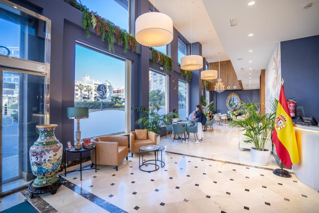 a lobby with tables and chairs and windows at Hotel Spa Cádiz Plaza in Cádiz