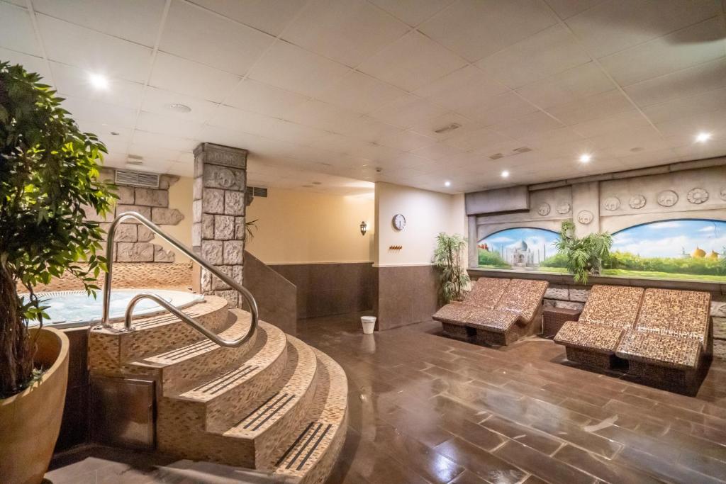 a lobby with benches and paintings on the walls at Hotel Spa Cádiz Plaza in Cádiz