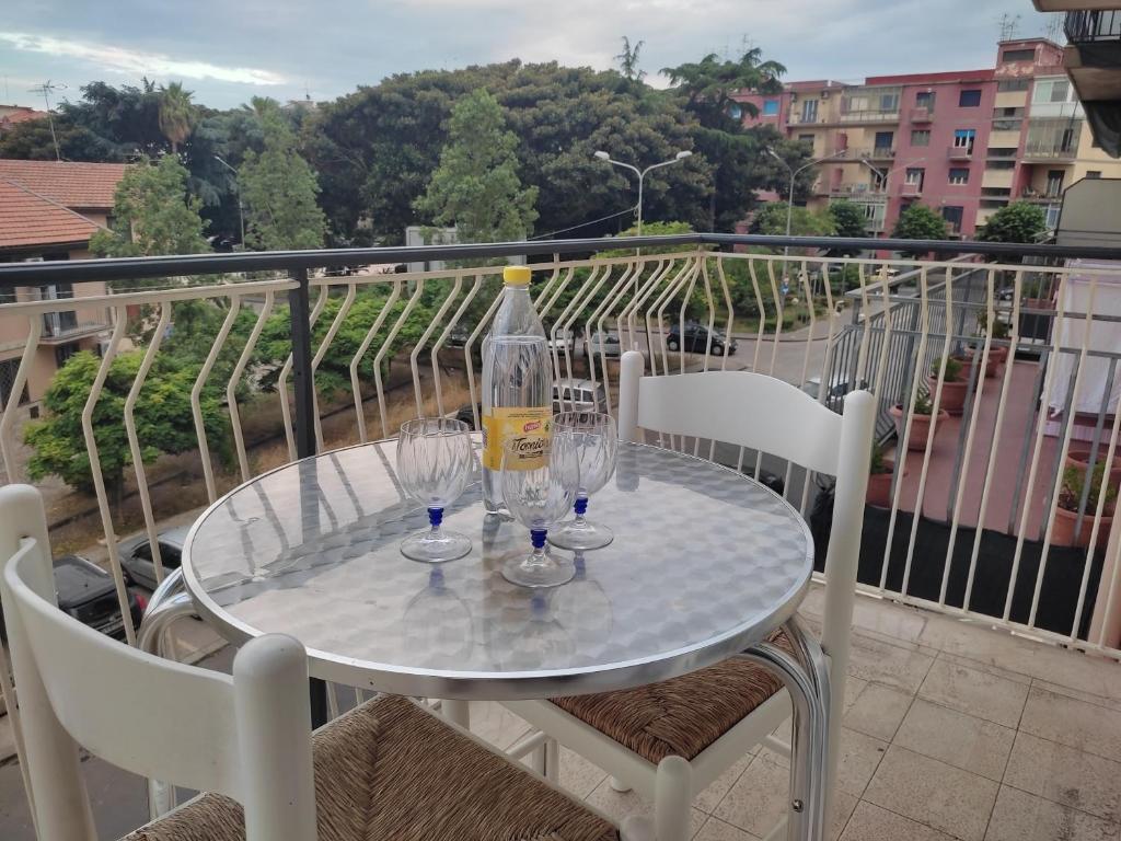 un tavolo in vetro con bicchieri da vino sul balcone di Don Aurelio in città ad Acireale