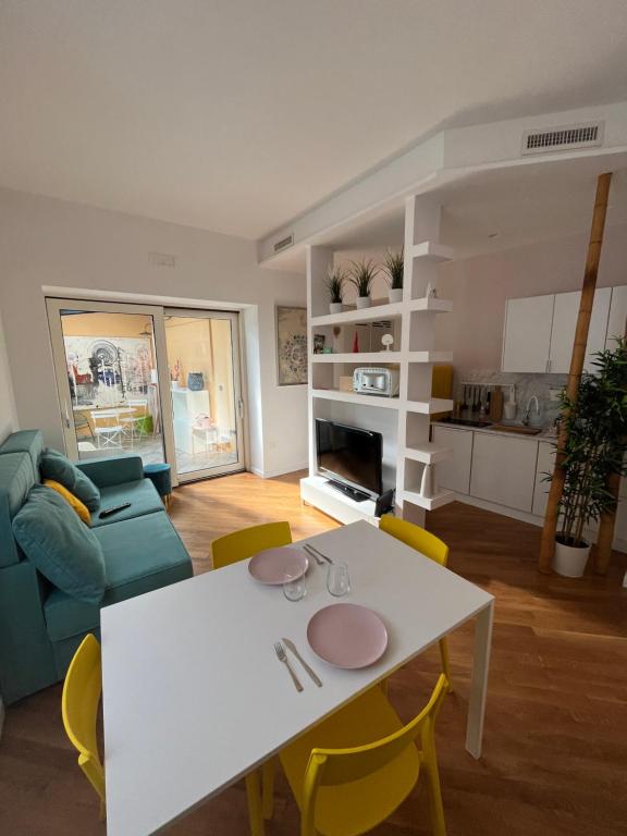 sala de estar con mesa blanca y sillas amarillas en Da Mauro Apartment, nel cuore di Marigliano en Marigliano