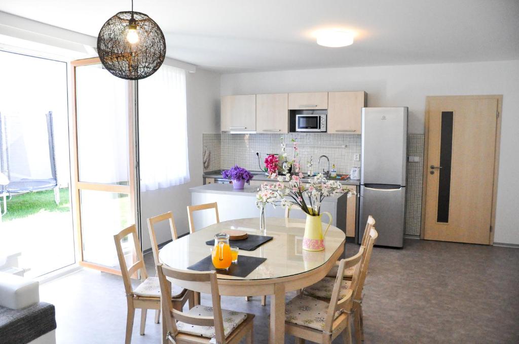 a kitchen and dining room with a table and a refrigerator at Rekreace na Lipně Atrium in Frymburk