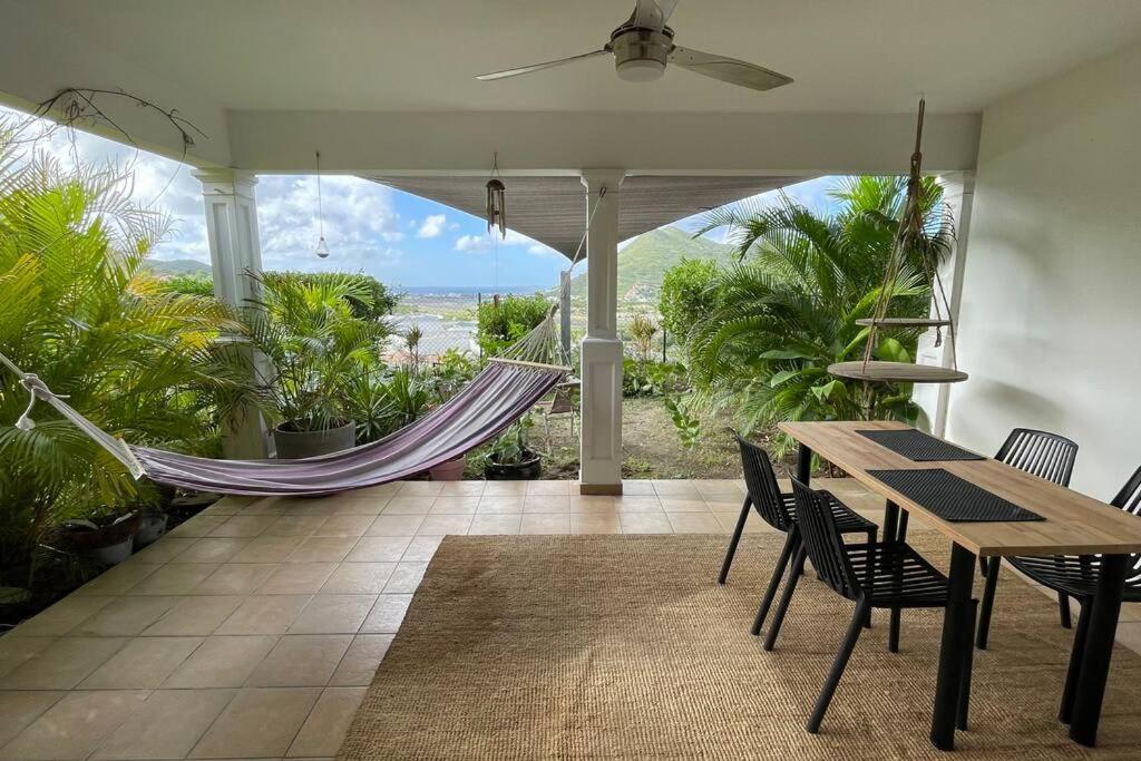 - une terrasse couverte avec un hamac, une table et des chaises dans l'établissement Sea views in Hope Estate, à Cul de Sac