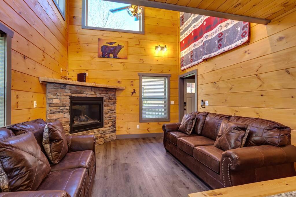 sala de estar con 2 sofás de cuero y chimenea en Dancing Bear Cabin- Relax & Enjoy!, en Sevierville