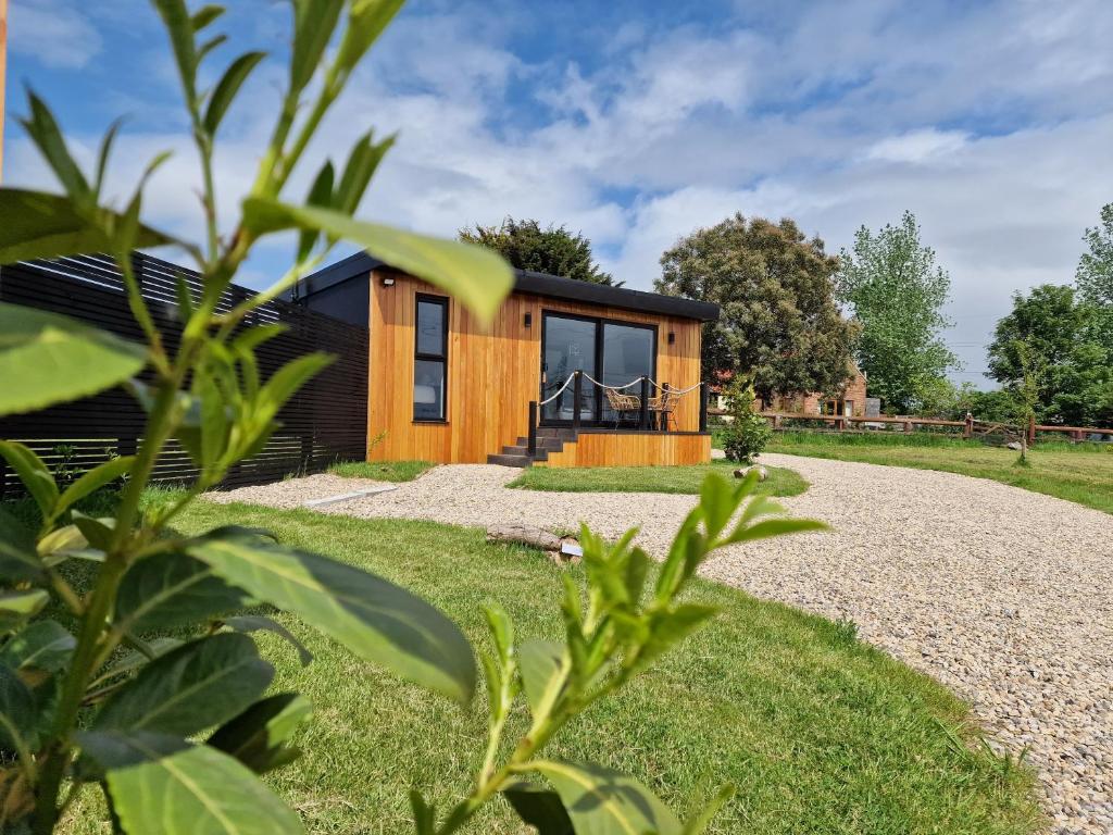 a small wooden house with a gravel driveway at TT Lodges in Stockton-on-Tees
