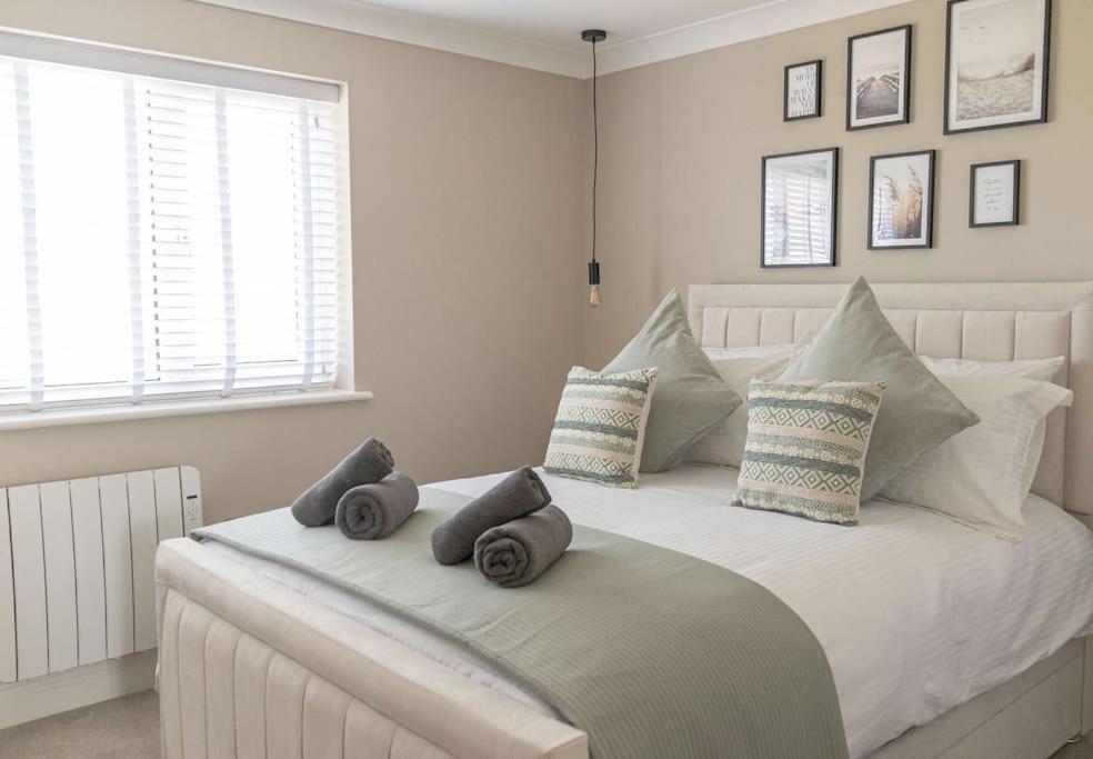 een slaapkamer met een wit bed met drie kussens erop bij The Rosewood, Cornwall. in Roche