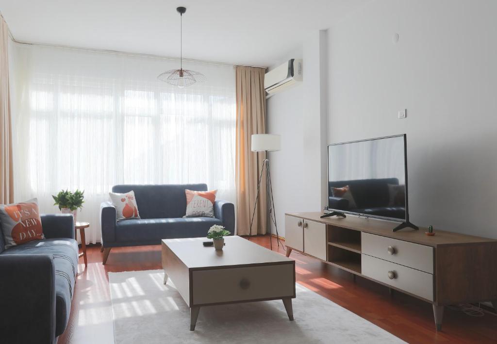 a living room with a couch and a tv at Merkezi Konumda Klimalı Aile Dostu Daire in Istanbul