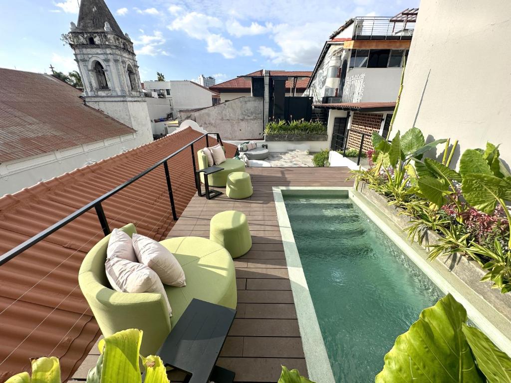 einen Balkon mit einem Pool und einem Gebäude in der Unterkunft AmazINN Places Deluxe Estudio Casa Marichu Casco Viejo in Panama-Stadt