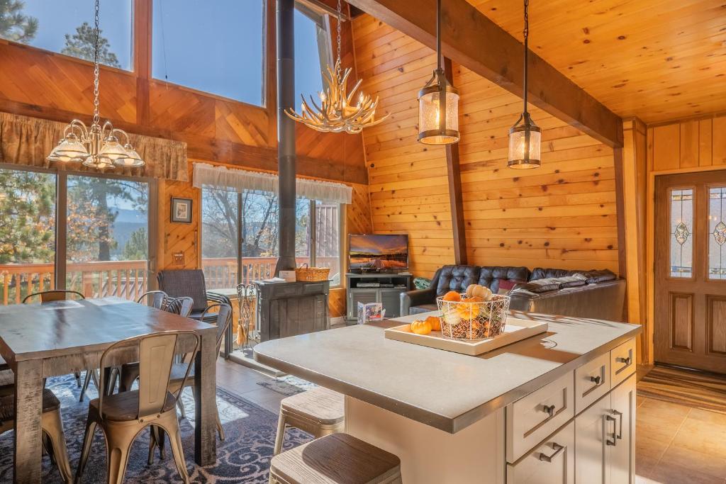 a kitchen and dining room of a cabin with a table and chairs at Fawnskin Family Cabin - Nicely decorated cabin with a lake view and a Foosball Table! in Fawnskin