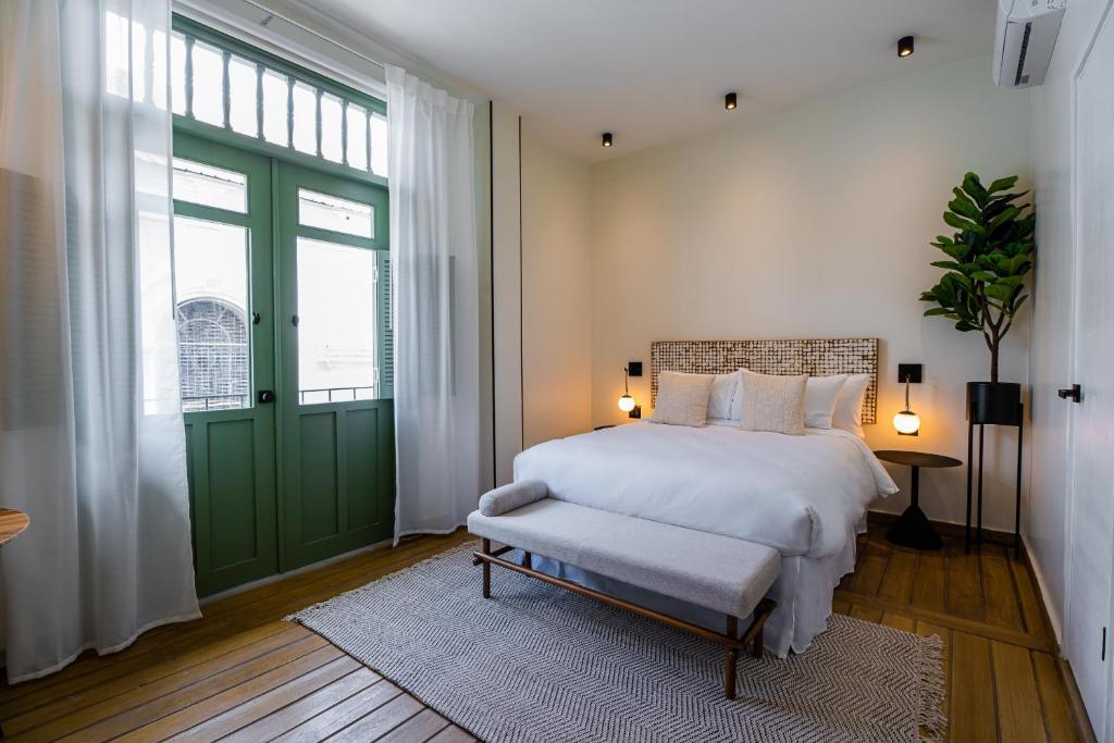 una camera con un letto e una porta verde di AmazINN Places Hotel Boutique Casa Marichu a Città di Panama
