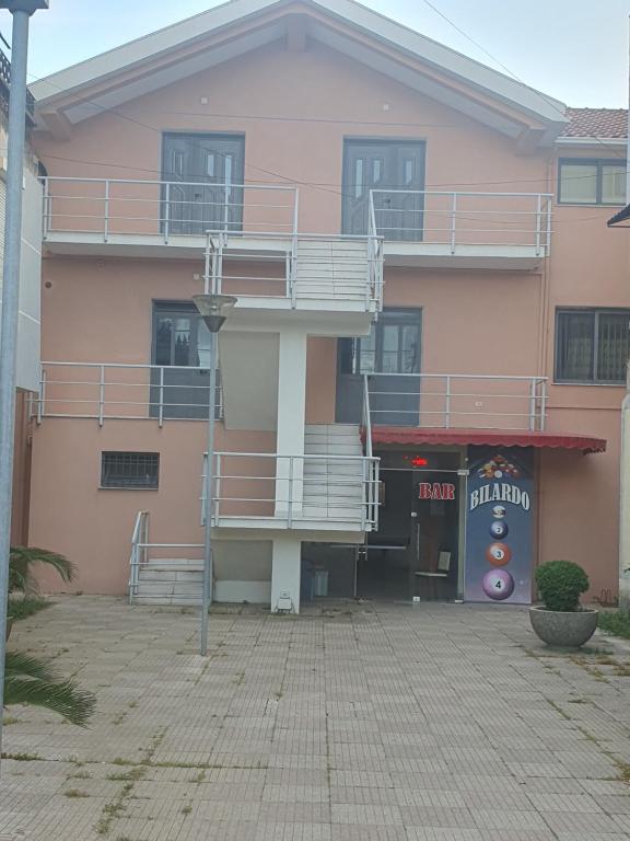 a pink building with balconies on the side of it at Gruda Apartments in Shkodër