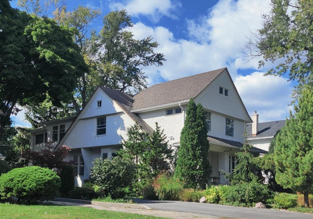 a white house with trees and bushes at Historic Oak Park Residence in Oak Park