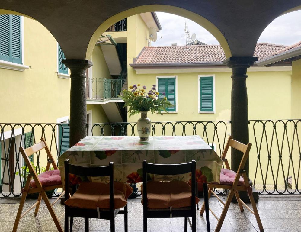 Taceno的住宿－La corte di via Chiarello，阳台上的桌椅和花瓶
