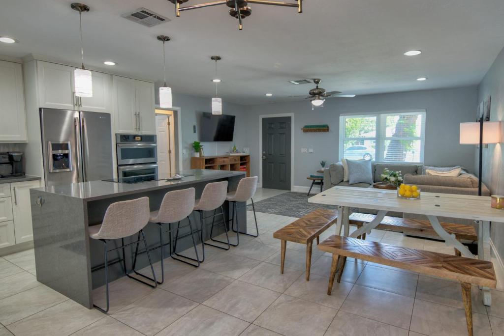a kitchen and living room with a table and chairs at Salt Water Heated Pool Home with a Tiki Bar, a Garage Game Room and 4 Bikes in Naples
